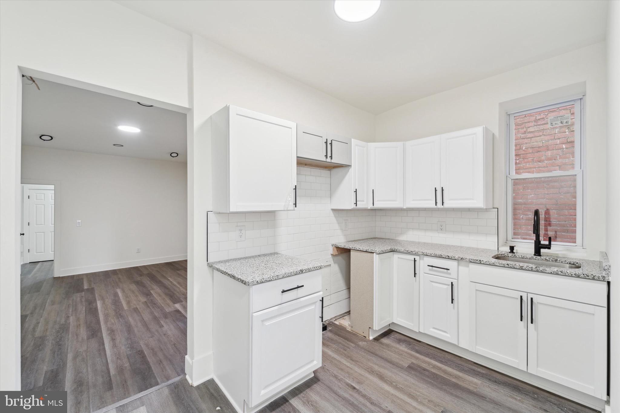316 East 11th Street Chester, PA 19013 - Photo 11 of 28 a kitchen with a sink window and cabinets