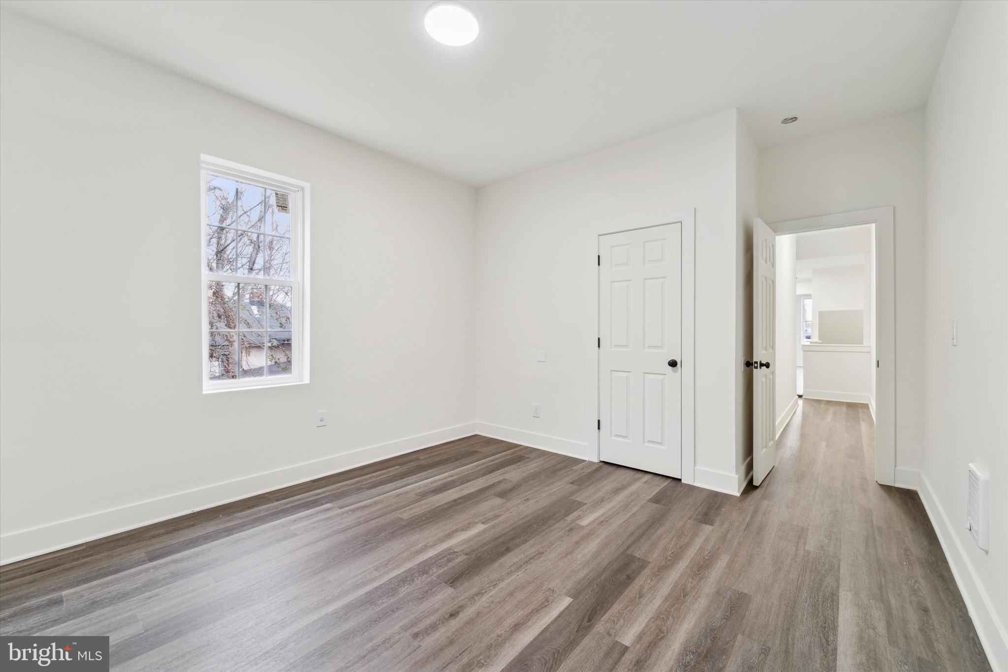 316 East 11th Street Chester, PA 19013 - Photo 21 of 28 an empty room with wooden floor and windows