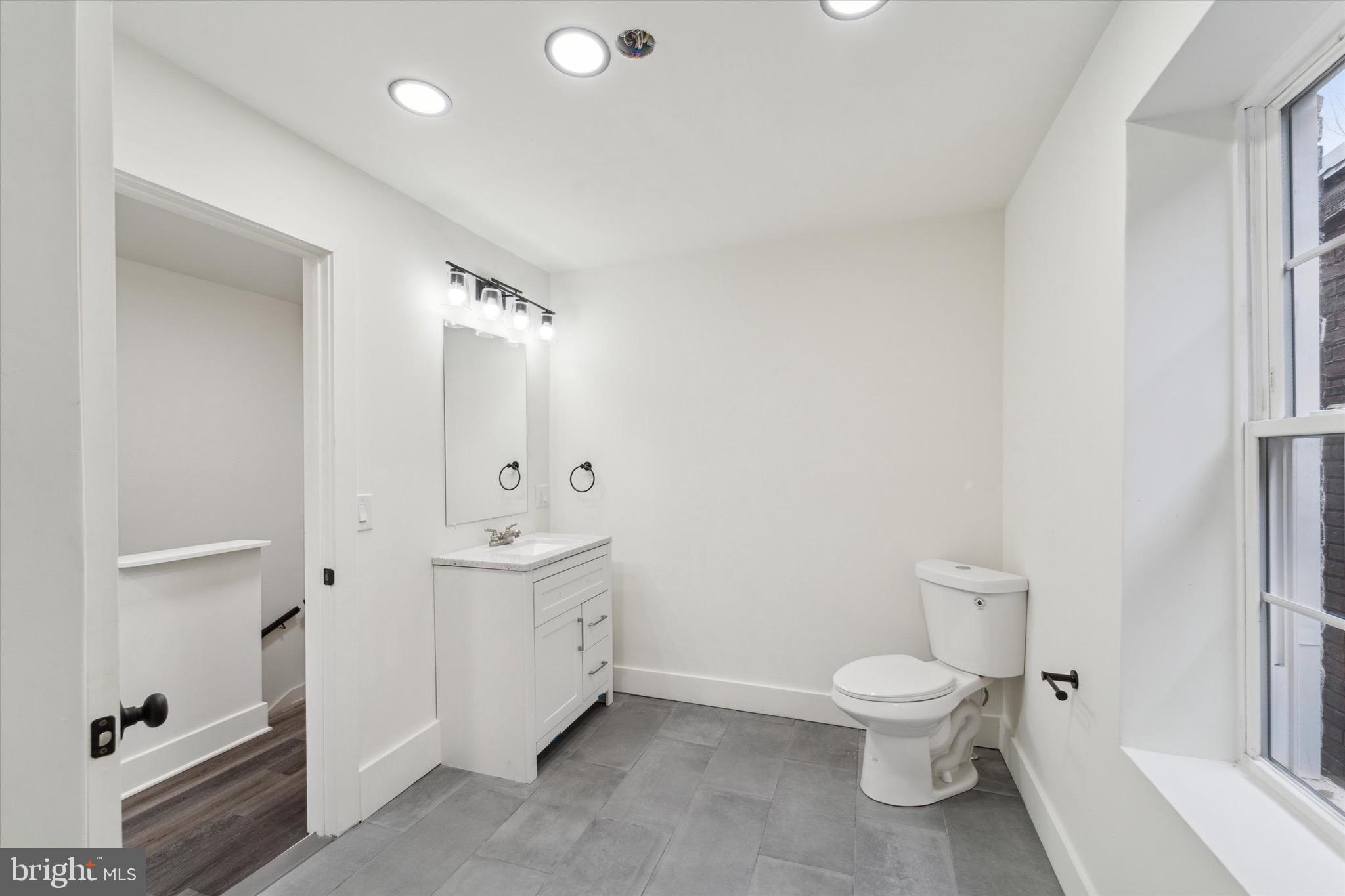 316 East 11th Street Chester, PA 19013 - Photo 24 of 28 a bathroom with a toilet a sink and mirror