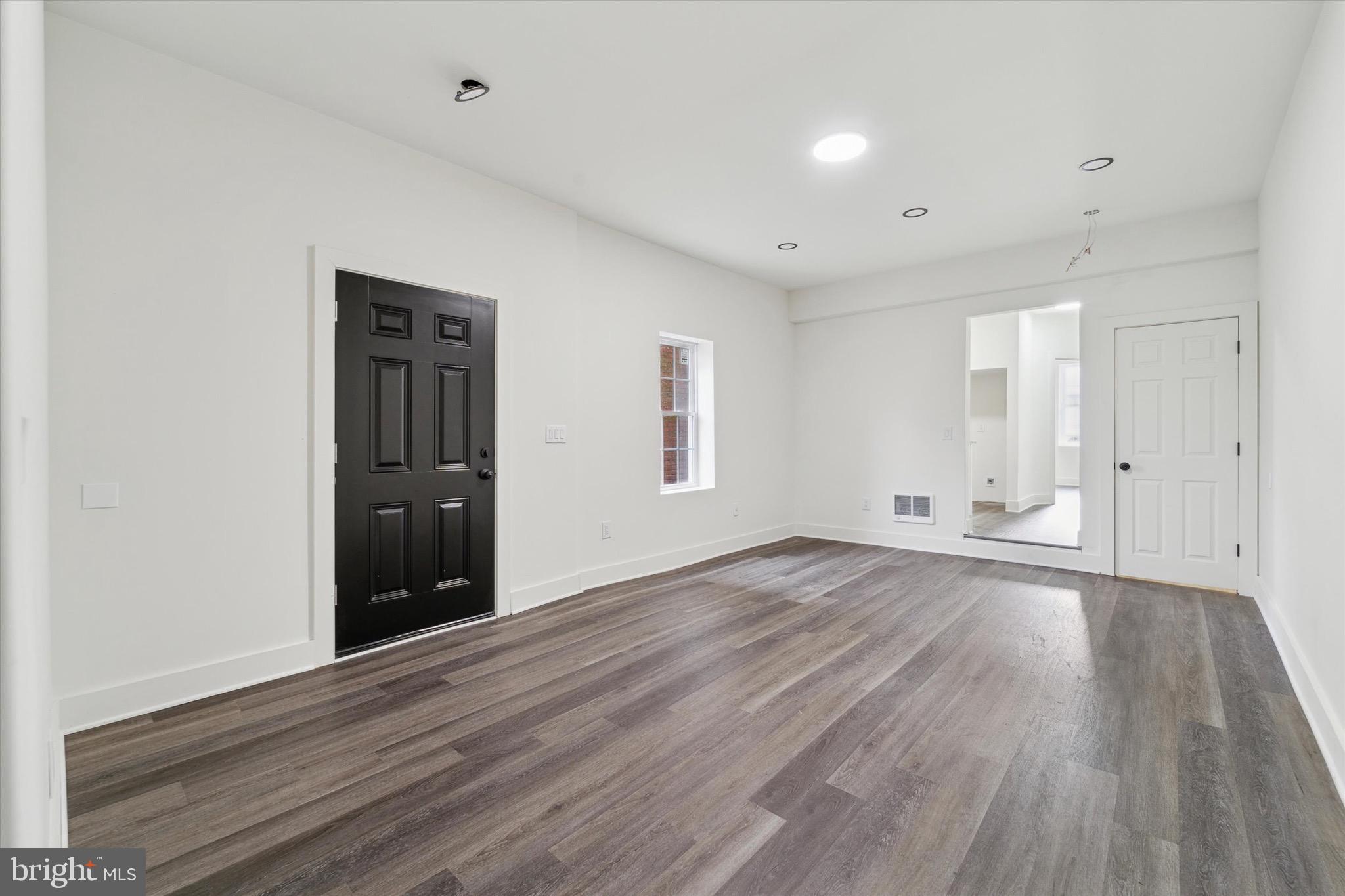316 East 11th Street Chester, PA 19013 - Photo 8 of 28 an empty room with wooden floor and windows