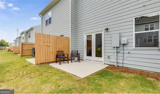 a view of a house with backyard and sitting area