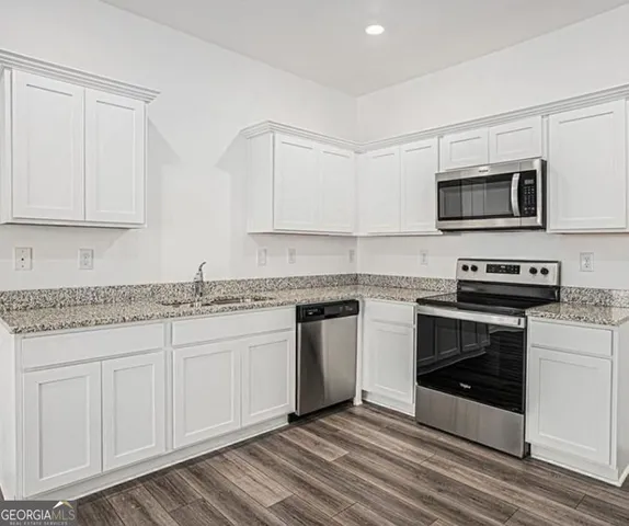 a kitchen with stainless steel appliances granite countertop a stove and a microwave