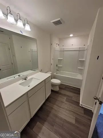 a bathroom with a sink mirror toilet and bathtub