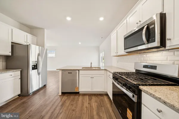a kitchen with stainless steel appliances a stove microwave and cabinets