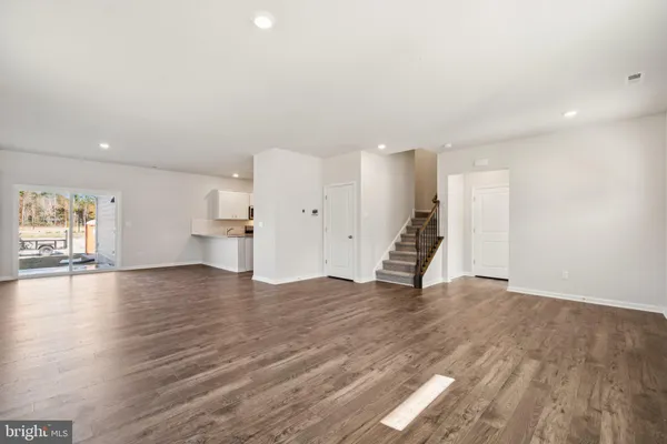 a view of empty room with wooden floor and window