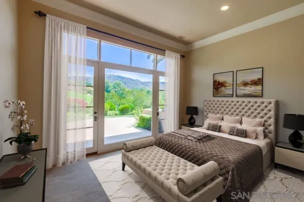 a bed sitting in a spacious bedroom next to a window