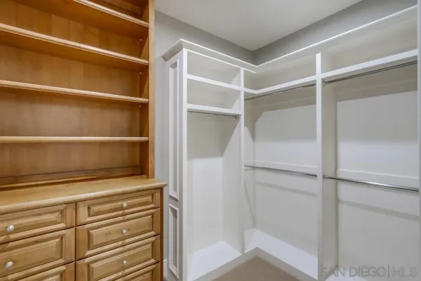 a view of walk in closet with empty racks