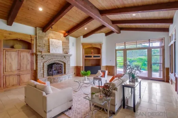 a living room with furniture fireplace and a large window