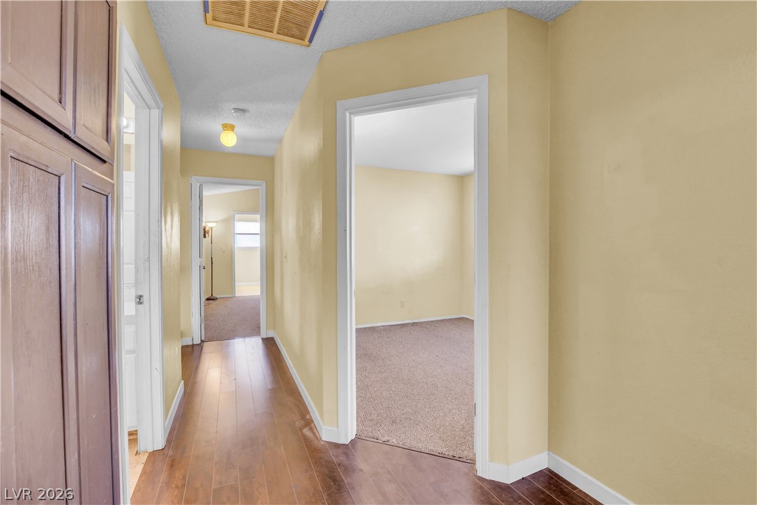 6440 Hartwood Road Las Vegas, NV 89108 - Photo 39 of 59 Rich wood flooring guides through this inviting interior hallway, connecting multiple living spaces.