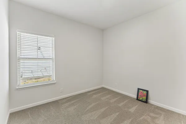 an empty room with a chandelier fan and entryway