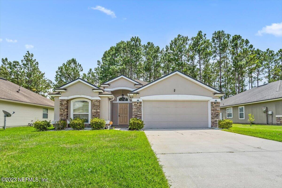 a front view of a house with a garden and yard