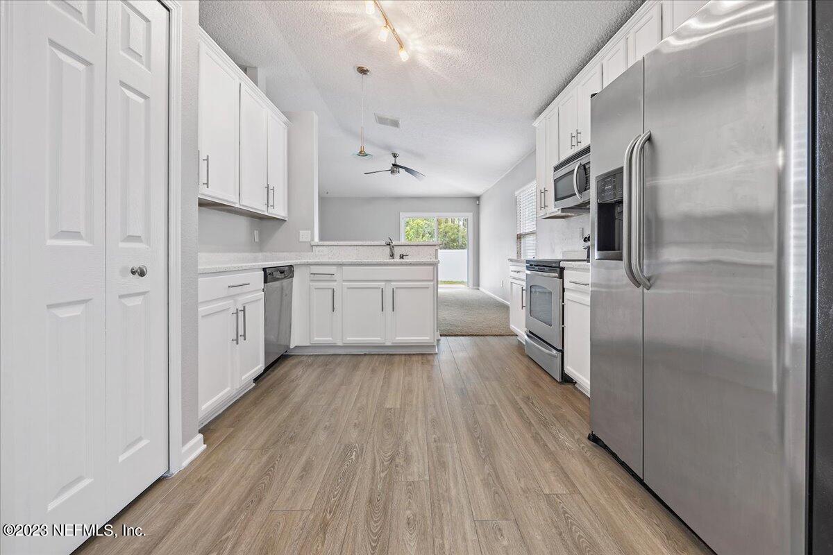 4046 Trail Ridge Road Middleburg, FL 32068 - Photo 7 of 22 a kitchen with white cabinets and stainless steel appliances