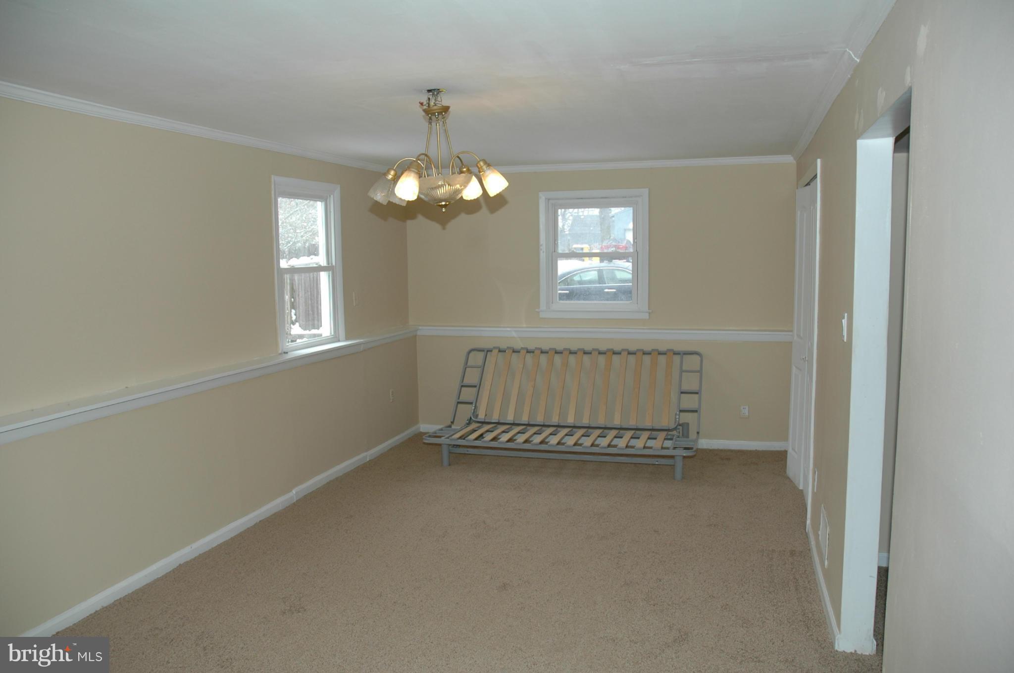 103 Mountain Road Linthicum, MD 21090 - Photo 12 of 17 an empty room with chandelier fan and windows