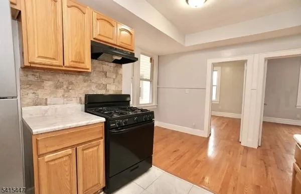 a kitchen with granite countertop wooden cabinets and a stove top oven