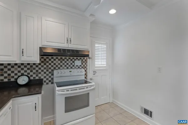 a kitchen with a stove and white cabinets