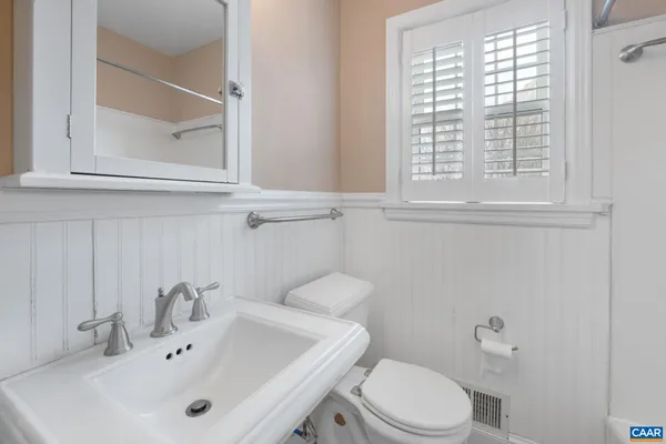 a bathroom with a sink a toilet and a window