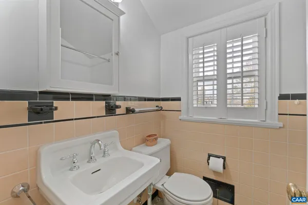 a bathroom with a sink a toilet and a window