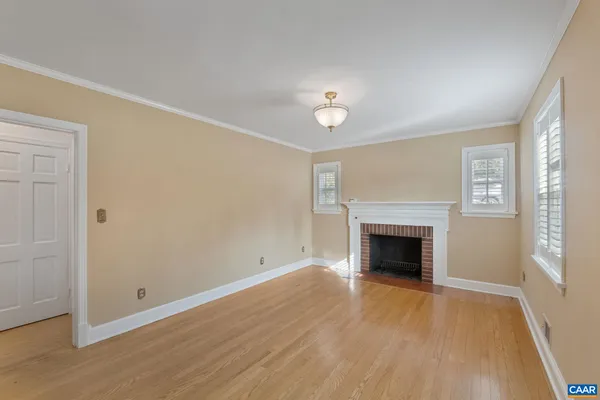 wooden floor fireplace and windows in an empty room