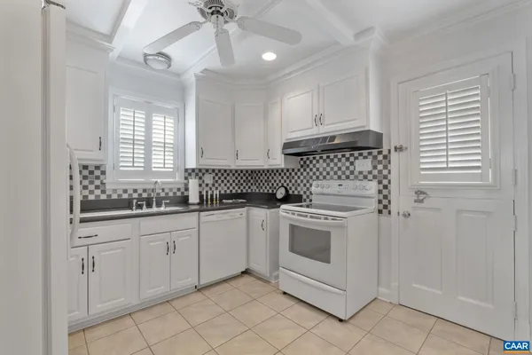a kitchen with white cabinets and white appliances