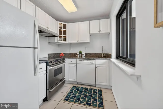 a kitchen with a stove oven and white cabinets