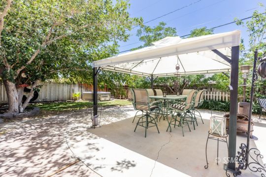 1021 West Iowa Avenue Ridgecrest, CA 93555 - Photo 38 of 40 a view of a patio with a table chairs and a backyard