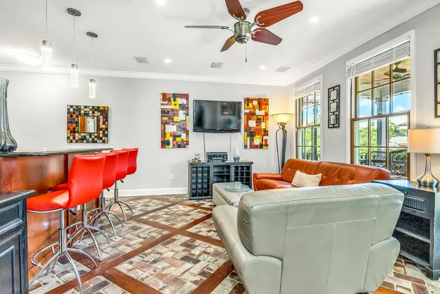 a living room with stainless steel appliances furniture and a flat screen tv