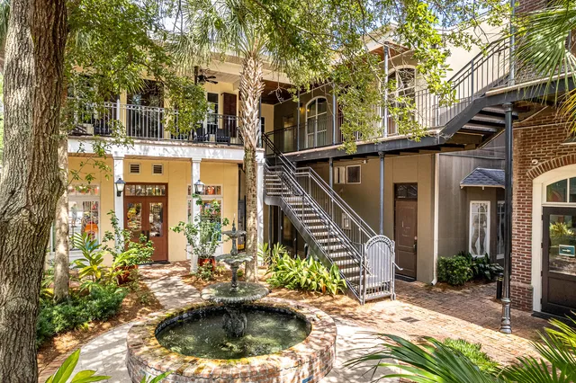 a view of house with a large windows and flower plants