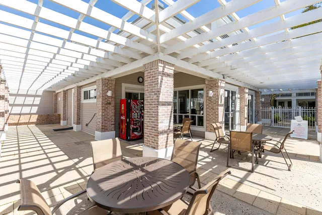 a view of a patio with table and chairs potted plants and palm tree