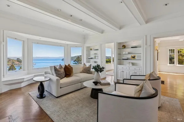 a living room with furniture floor to ceiling window and wooden floor