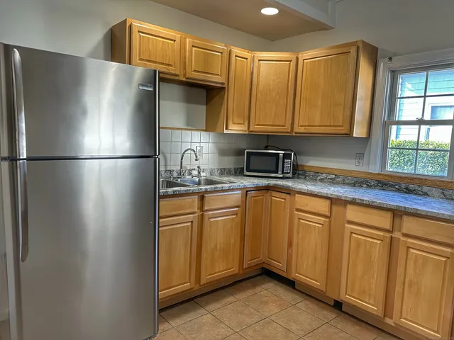 a kitchen with stainless steel appliances granite countertop a refrigerator a sink and cabinets