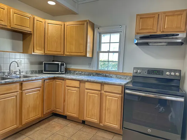 a kitchen with stainless steel appliances granite countertop a sink stove and cabinets