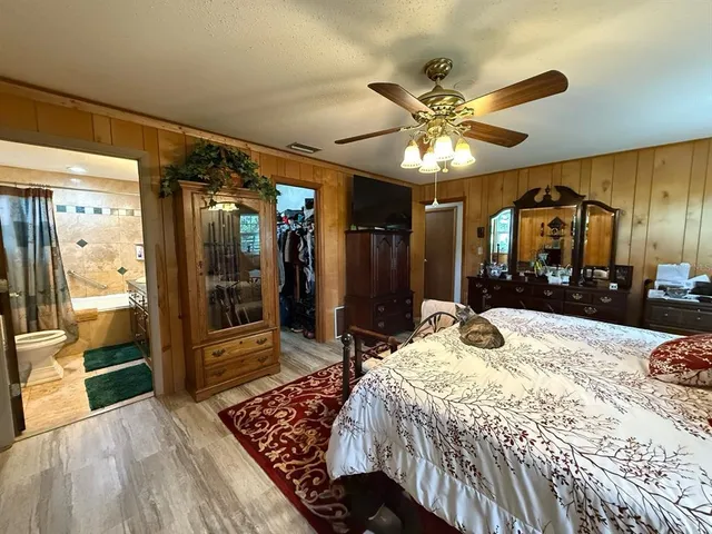 a bedroom with a large bed and a chandelier