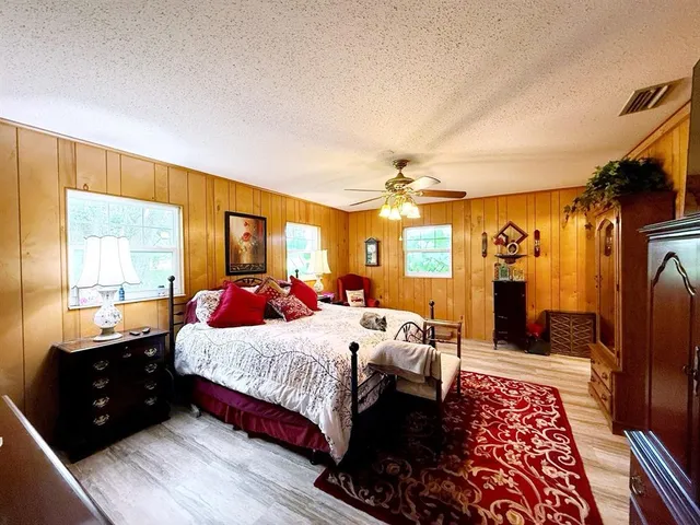 a bedroom with a large bed and wooden floor