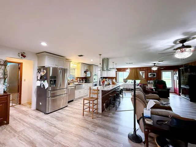 a living room with furniture kitchen view and a refrigerator