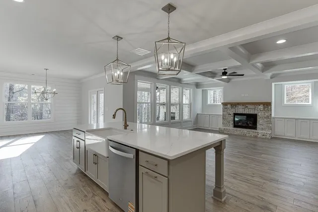 a large white kitchen with a chandelier