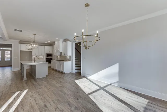 a kitchen with kitchen island white cabinets and stainless steel appliances