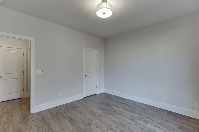 a view of a room with wooden floor and white walls
