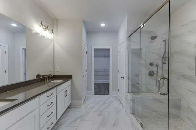 a spacious bathroom with a granite countertop sink mirror and shower