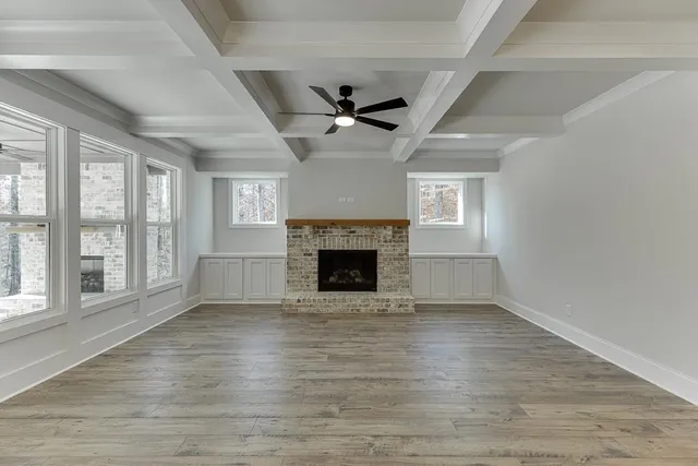 wooden floor fireplace and windows in an empty room