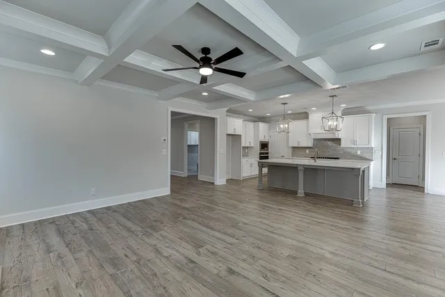 a view of kitchen with kitchen island wooden floor center island and stainless steel appliances