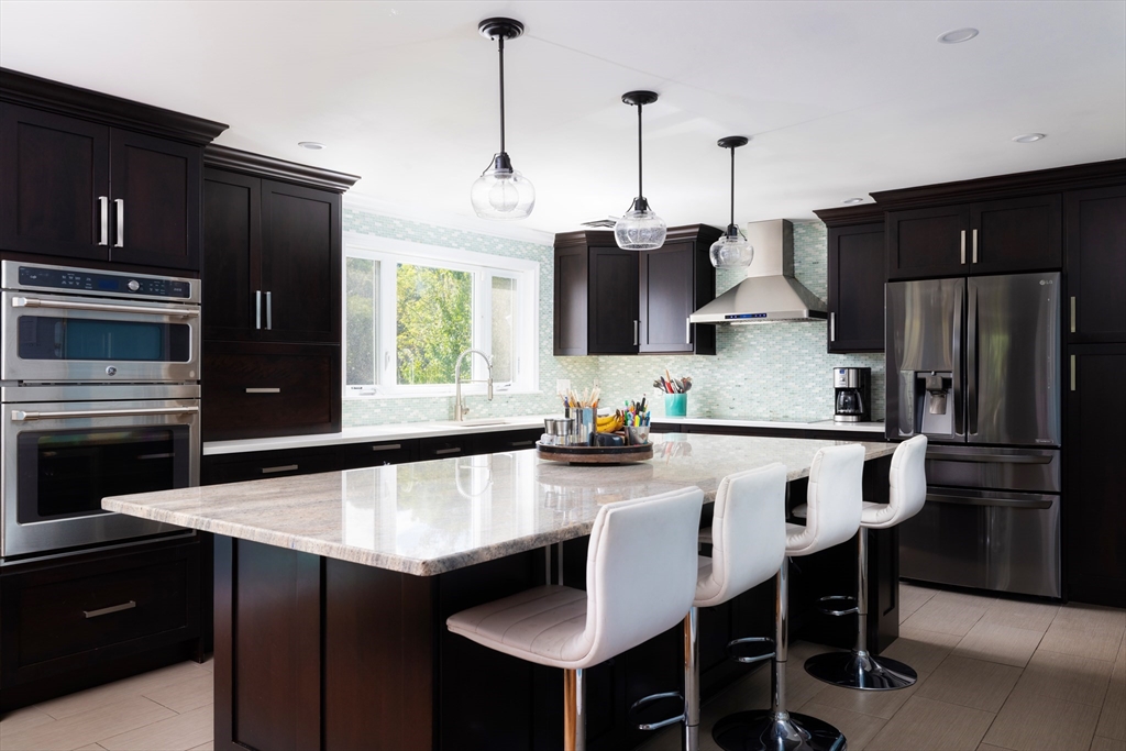45 Brandeis Road Newton, MA 02459 - Photo 4 of 12 a kitchen with stainless steel appliances a table chairs and refrigerator