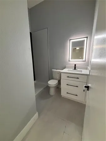 a bathroom with a sink a toilet a mirror and shower