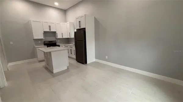 a kitchen with refrigerator and white cabinets