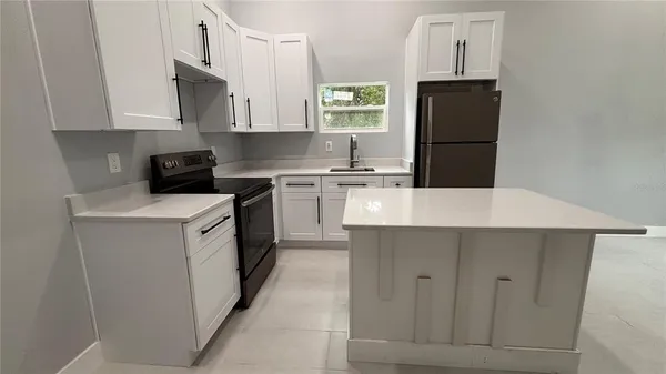 a kitchen with a white cabinets stove and refrigerator