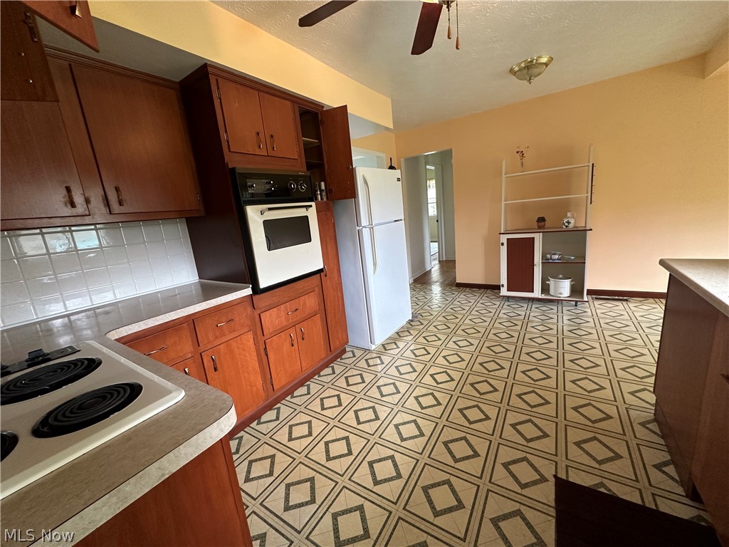 2408 Brown Road Ashtabula, OH 44004 - Photo 7 of 27 Kitchen featuring white appliances, backsplash, ceiling fan, and light tile floors