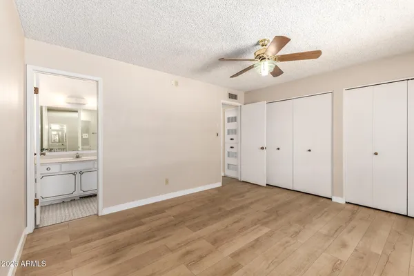 a view of a room with a ceiling fan and a hardwood floor