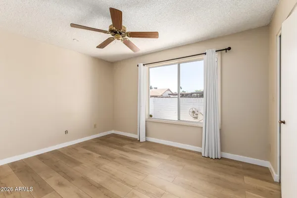 an empty room with a window and a ceiling fan