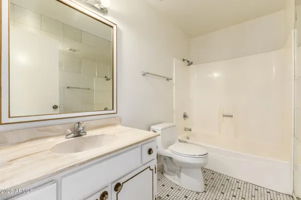 a bathroom with a granite countertop sink toilet a shower and a mirror