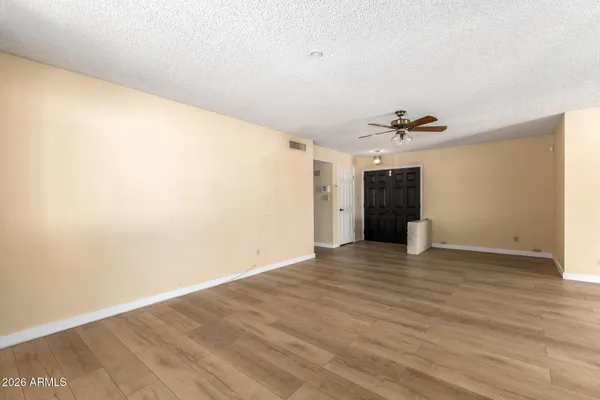 a view of an empty room with wooden floor