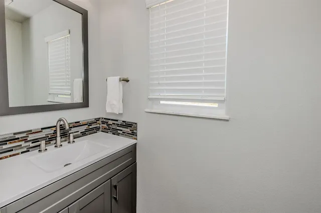 a kitchen with granite countertop white cabinets and stainless steel appliances